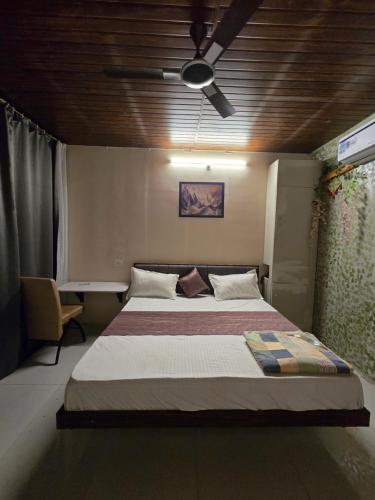 a bedroom with a large bed with a ceiling at Shyam Resort in Khandwa