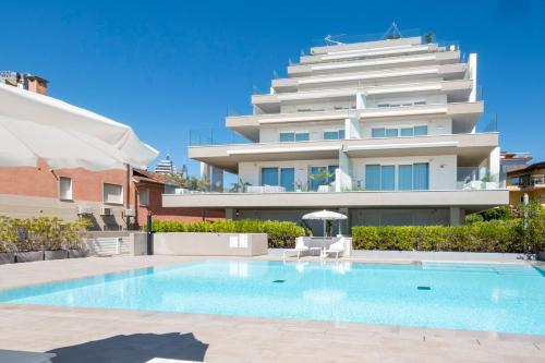 ein Schwimmbad vor einem großen Gebäude in der Unterkunft Vibra Tahiti Comfort in Lido di Jesolo