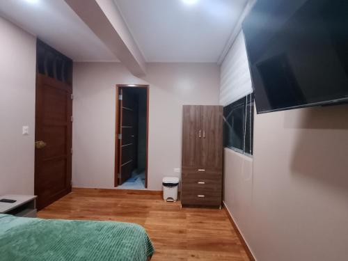 een slaapkamer met een bed en een flatscreen-tv bij Casa Sol in Tingo María