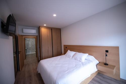 una camera con letto bianco e TV a schermo piatto di Casa Avó Libânia a Murça