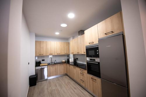 una cucina con mobili in legno e un frigorifero in acciaio inossidabile di Casa Avó Libânia a Murça