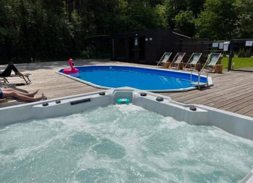 een zwembad met een hot tub in de achtertuin bij Krasne Residence & Spa - STREFA CISZY in Krasne
