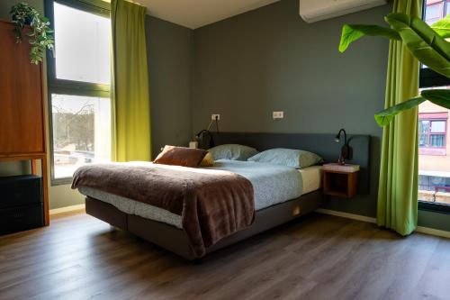 a bedroom with a bed with green walls and wooden floors at Short Stay Wageningen in Wageningen