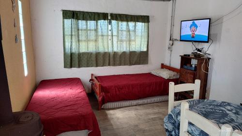 een slaapkamer met 2 bedden en een tv. bij La Arbolada in Mar del Plata