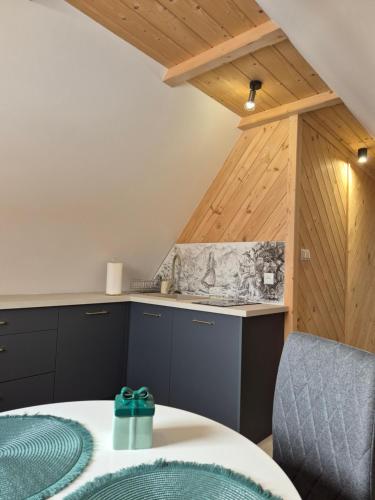 una cucina con armadi neri, tavolo e bancone di Kozie Turnie a Poronin