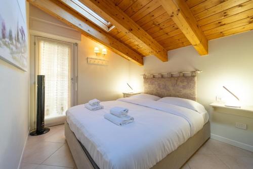 ein Schlafzimmer mit einem großen weißen Bett mit Handtüchern darauf in der Unterkunft Apartment with SwimmingPool and view in Tremezzo