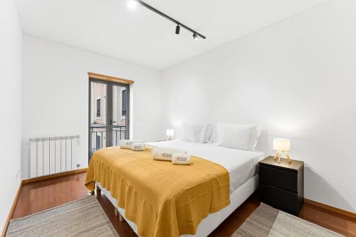 a white bedroom with a large bed and a window at GuestReady - Cosy Gaia Retreat in Vila Nova de Gaia