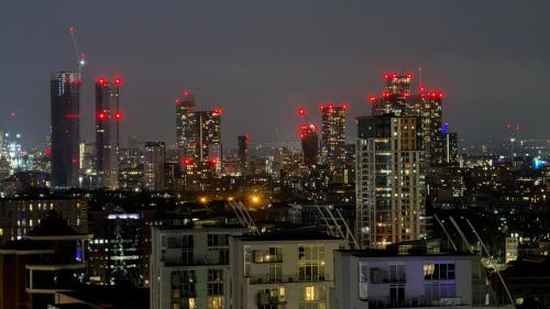 a view of a city at night with red lights at Panoramic City Views Elegant 2BR, 2 Min to Metro in Manchester
