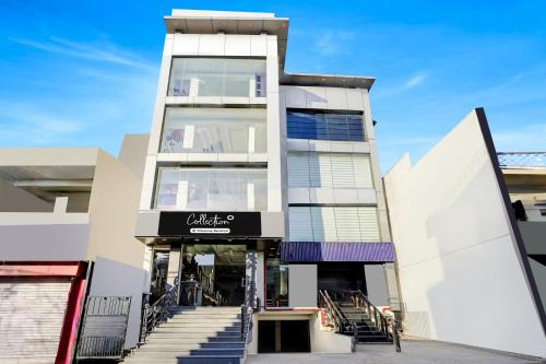 een hoog gebouw met trappen ervoor bij Collection O Prem Nagar Dehradun Formerly Hotel Parjaat Residency in Dehradun