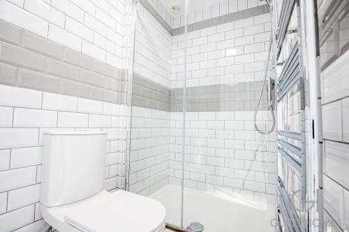 a white bathroom with a toilet and a shower at Guest Stays - Bridge Street Apartment in Evesham