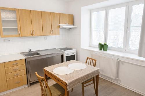 een keuken met een tafel, stoelen en een spoelbak bij Apartmán František in Loštice