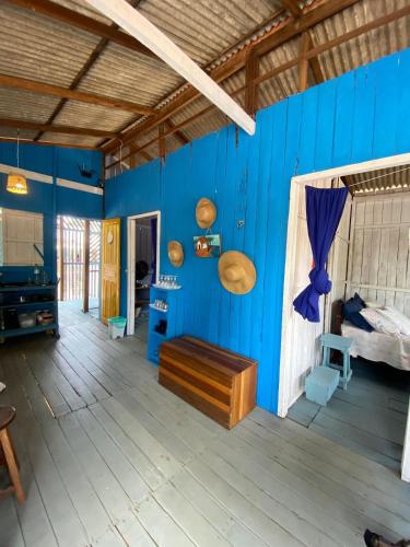 a blue room with a bed and a wooden floor at Casa de Praia LUÁ in Bragança