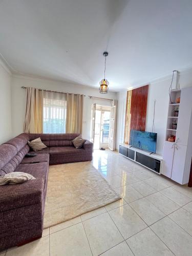 een woonkamer met een bank en een tv bij DK Homes in Bunamwaya