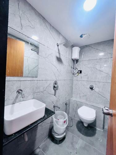 a bathroom with a sink and a toilet at Hotel Sun Lake in Ahmedabad
