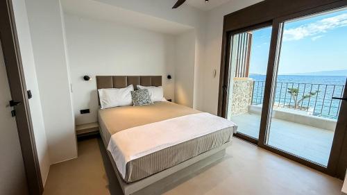 een slaapkamer met een bed met uitzicht op de oceaan bij Eosea Selene in Ierissos