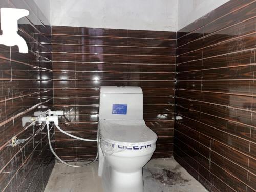 a bathroom with a toilet in a room with wooden walls at Prime Hotel in Kannauj