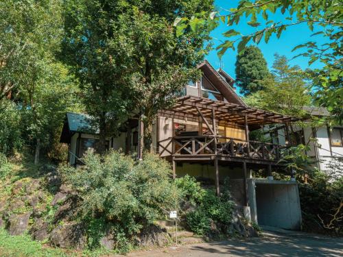 a house on a hill with a tree at Kurokawa Mori No Kiki in Minamioguni
