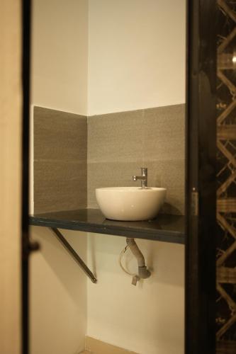 un lavandino bianco su un bancone in un bagno di Thekkady Arasi Hotel a Thekkady