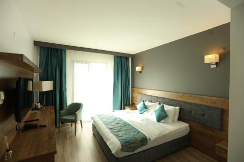 a bedroom with a bed and a chair and a window at Lina Garden Otel in Bingol