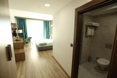 a bathroom with a toilet and a bedroom with a bed at Lina Garden Otel in Bingol