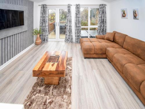 - un salon avec un canapé brun et une table basse dans l'établissement Bluebird Lodge 2 - Uk50932, à High Nibthwaite