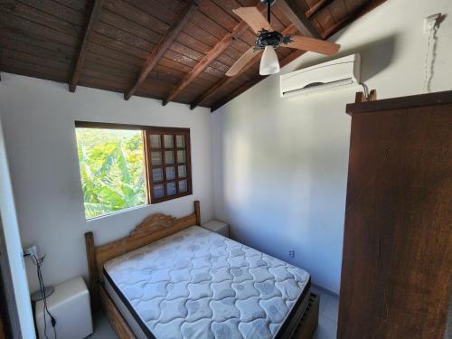 a bedroom with a bed and a ceiling fan at Casablanca do Rosa in Praia do Rosa