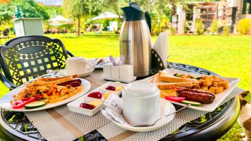 a table with two plates of food and a kettle at Rio Eco Gardens Hotel in Nairobi