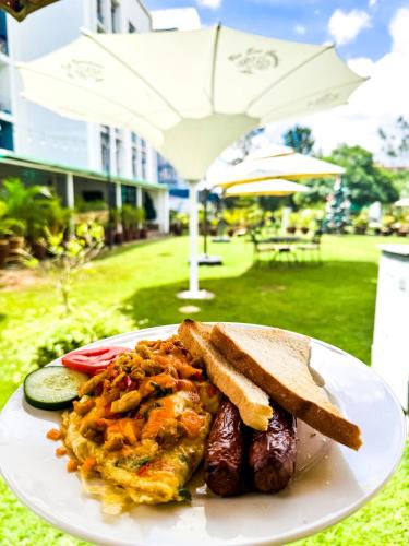 a plate of food with bread and meat and toast at Rio Eco Gardens Hotel in Nairobi