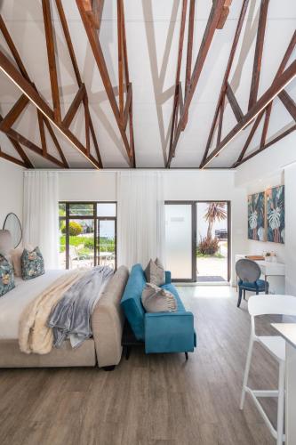 a bedroom with a large bed and a blue couch at 2 On Lismore Guesthouse in Tokai
