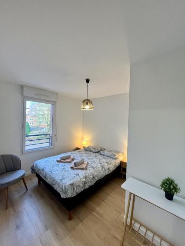 ein Schlafzimmer mit einem Bett, einem Stuhl und einem Fenster in der Unterkunft L'écrin Lensois - 57 m2 - 6 personnes - parking in Lens