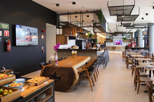 un ristorante con un grande tavolo e sedie in legno di IBIS PRIMAVERA DO LESTE a Primavera do Leste