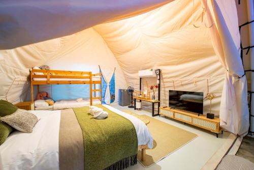een slaapkamer met een bed in een tent bij Camping&Cafe Khao Phratamnak in Pattaya South