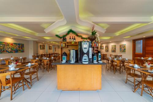 un ristorante con tavoli e sedie e un registratore di cassa di Hotel Laghetto Premio a Gramado