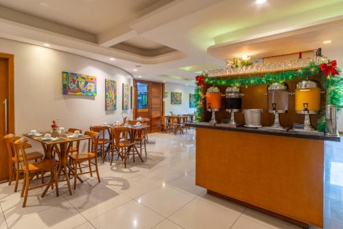 un ristorante con tavoli e sedie e un bar di Hotel Laghetto Premio a Gramado