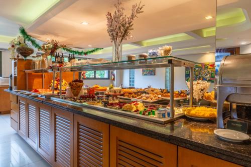 una linea a buffet con molti tipi diversi di cibo di Hotel Laghetto Premio a Gramado
