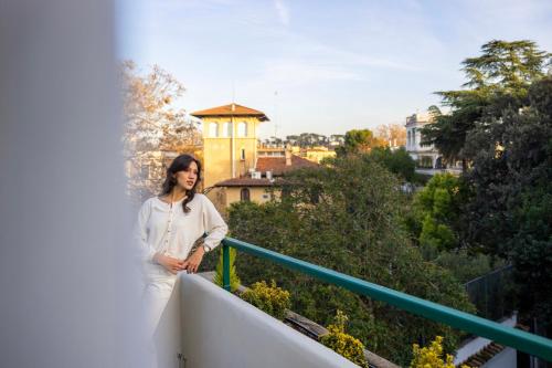 a woman standing on a balcony of a building at Boutique Hotel Maria Vittoria in Rome
