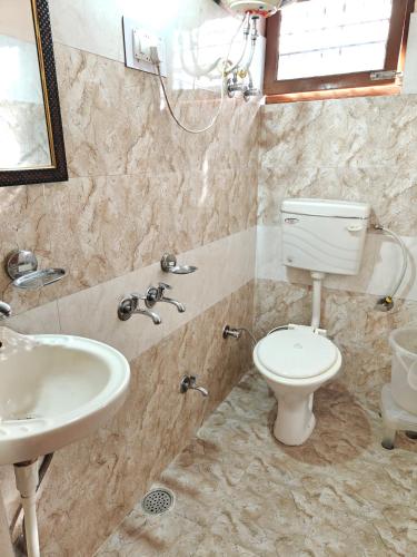 a bathroom with a toilet and a sink at Happy Mountains in Nārkanda