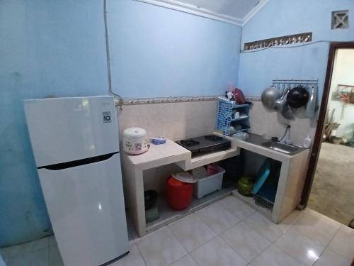 a small kitchen with a refrigerator and a sink at Mangga in Sengkaling