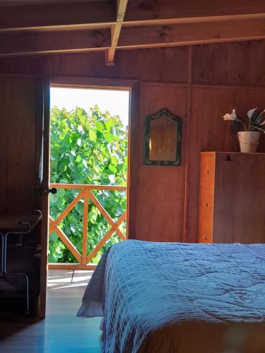 a bedroom with a bed and a door with a window at Calafates y lavandas in Chile Chico