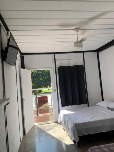 a bedroom with a bed in a room with a window at Dona Floripes Flats in Campinas