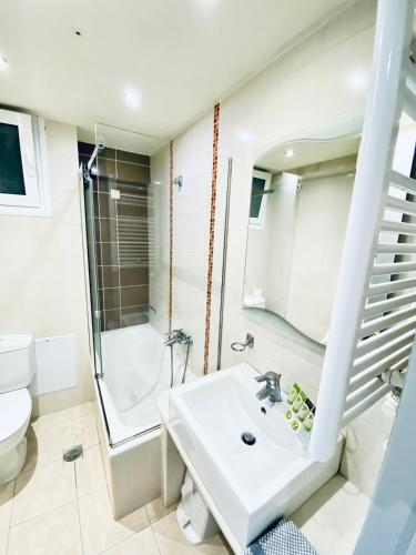 a bathroom with a sink and a shower and a toilet at New Aegli Resort Hotel in Poros