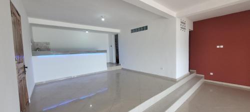 an empty room with a large window and a white wall at Villa Alicia Vavindrano in Fort Dauphin