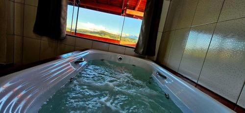 una vasca idromassaggio in un bagno con finestra di Oasis na montanha a Bueno Brandão