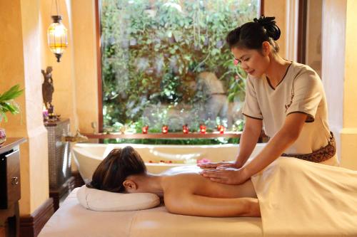 a woman giving a woman a massage in a room at Burasari Phuket Resort & Spa in Patong Beach