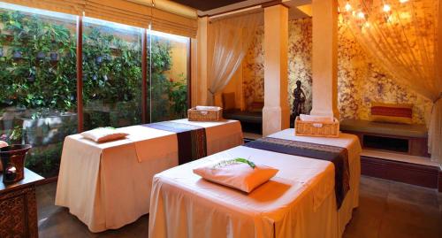 a room with two beds and a window at Burasari Phuket Resort & Spa in Patong Beach