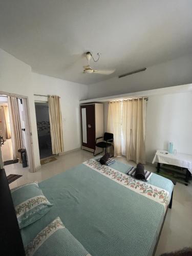 a bedroom with a large bed and a desk at Varkala Beats - Traveller's Pad in Varkala
