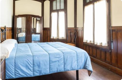 a bedroom with a bed with a blue blanket on it at Palacio de la Monstrua in Avilés