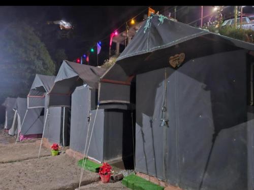 a row of tents on the beach at night at Himalayan Wooden Cottage camping & Cafe Dalhousie in Dalhousie