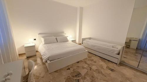 een witte slaapkamer met een bed en een spiegel bij Casa Alisella in Milaan
