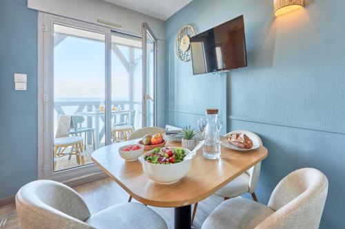 a dining room with a table with a bowl of fruit at Résidence Pierre & Vacances Les Tamaris in Trouville-sur-Mer